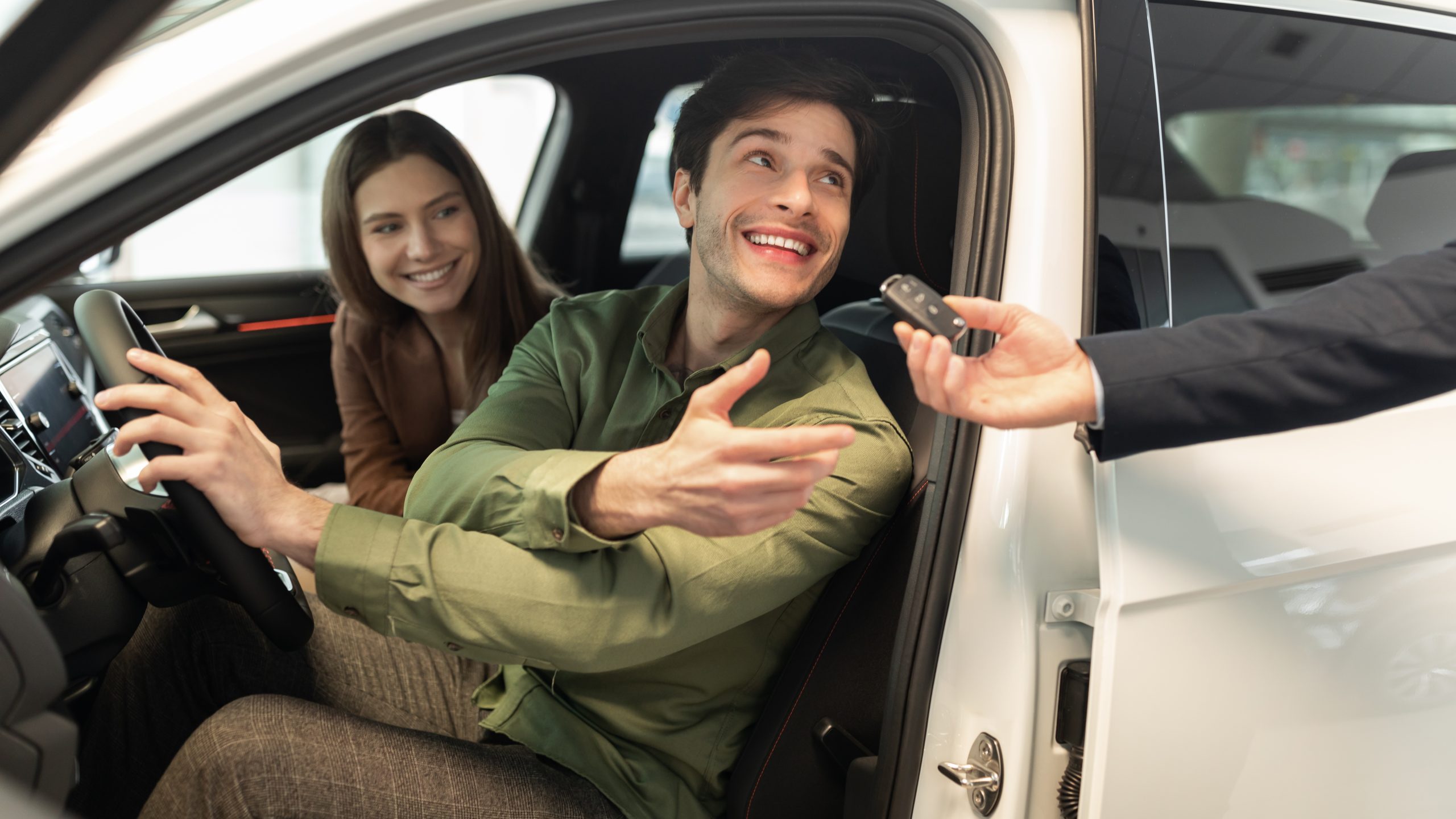 Happy,Millennial,Couple,Taking,Car,Key,From,Auto,Salesman,,Sitting