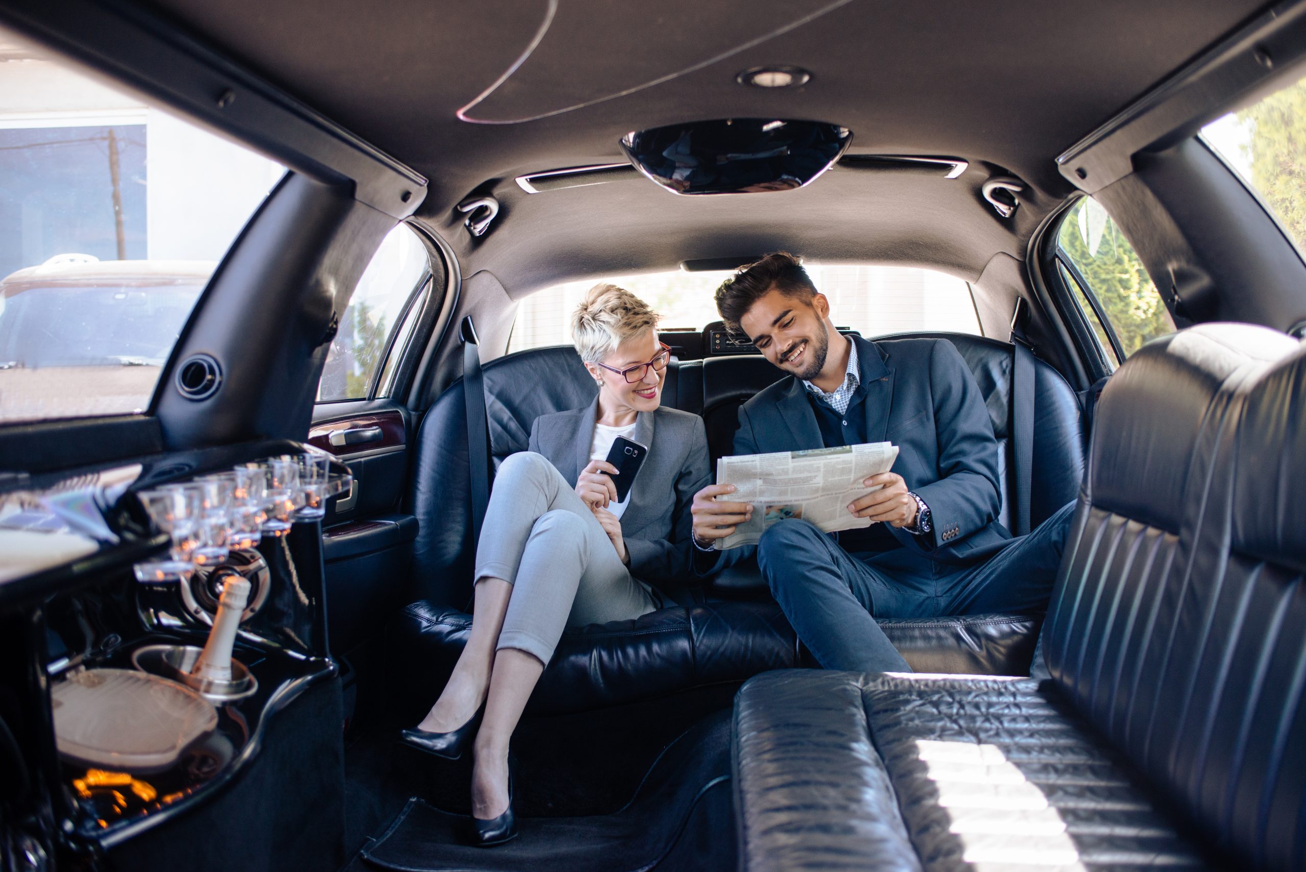 Partners,In,Limo,Looking,At,Newspaper,,Getting,Informed